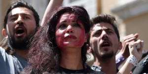 Afghan artists on April 27, 2015 perform a role play to depict the lynching of Afghan woman Farkhunda, 27, who was attacked by an angry mob, in Kabul. Farkhunda was beaten with sticks and stones, thrown from a roof, before being run over by a car outside a mosque in Kabul on March 19. The mob then set her body ablaze and dumped it in a river as police allegedly looked on. AFP PHOTO / SHAH Marai        (Photo credit should read SHAH MARAI/AFP/Getty Images)